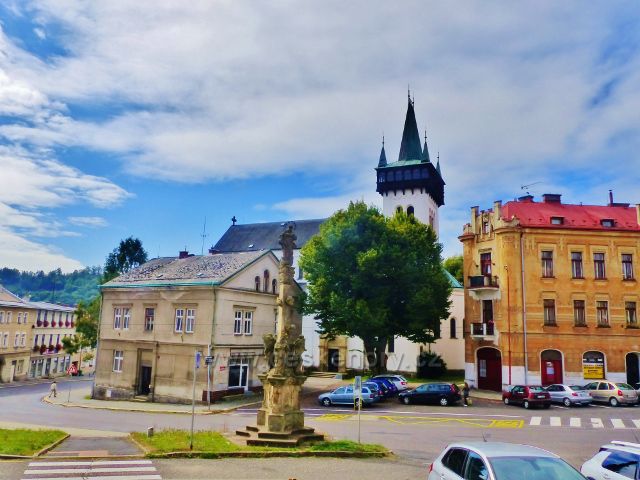 Semily - Komenského náměstí s Mariánským sloupem. V pozadí vyčnívá věž kostela sv. Petra a Pavla