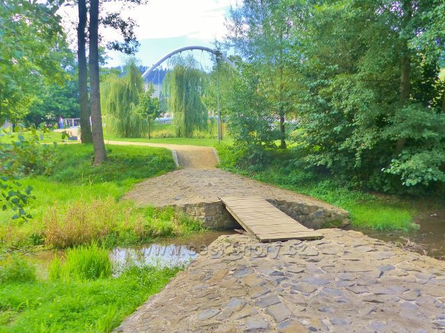 Semily - mostek přes Semilský náhon v Parku Ostrov. V pozadí obloukový most pro pěší přes Jizeru