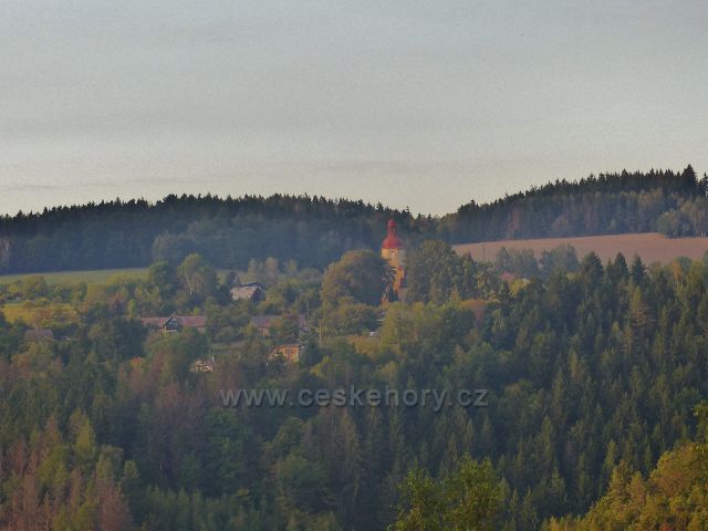 Pohled ze Závrší na kostel Nejsvětější Trojice v obci Bzí