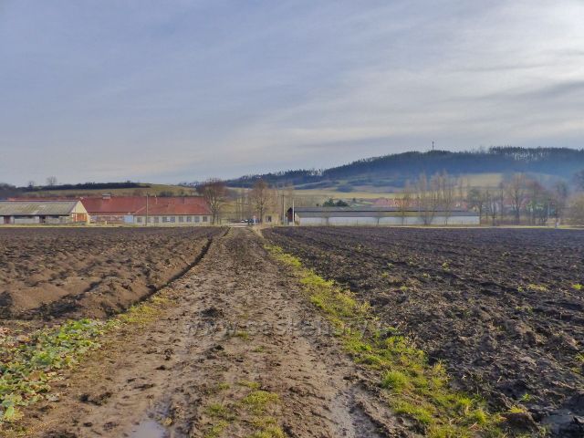 Jabloňany - zpětný pohled z trasy po zelené TZ k zemědělským objektům na okraji obce. V pozadí bezejmenný vrch(445 m.n.m.) s telekomunikační věží