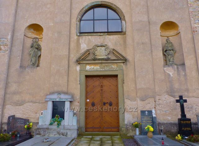 Homol - vstupní portál s erbem zakladatelky kostela. Vlevo ve výklenku je socha Ježíše Krista a v pravém výklenku je socha Panny Marie Bolestné, patronky kostela