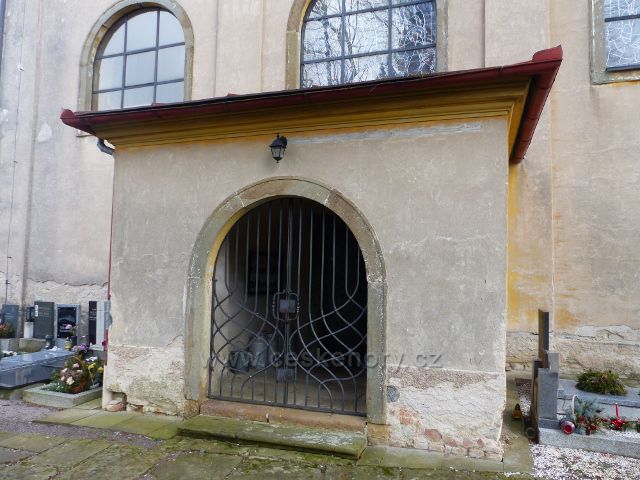 Homole - boční vchod do kostela s tepanou železnou mříží
