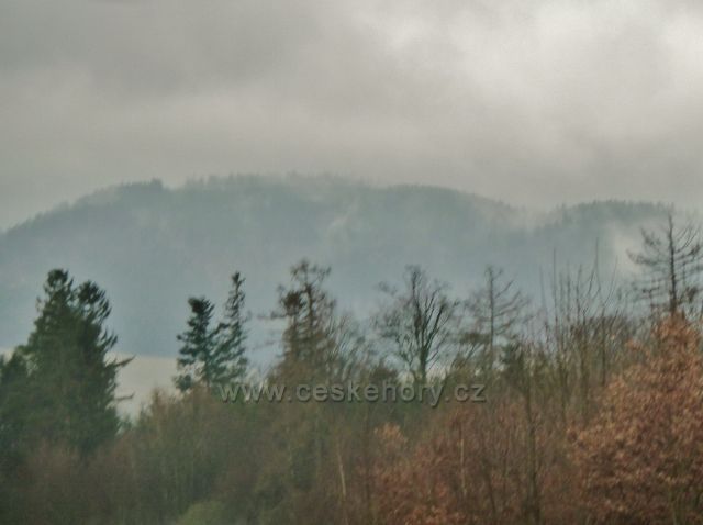 Vadětín - pohled přes "zoom" na 4 km vzdušnou čarou vzdálený Kubincův kopec zahalený převalující se mlhou