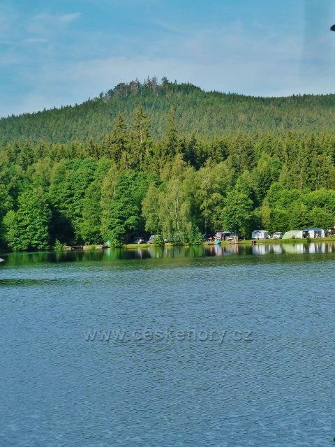 Milovy - pohled přes Milovský rybník na Malinskou skálu (811 m.n.m.)