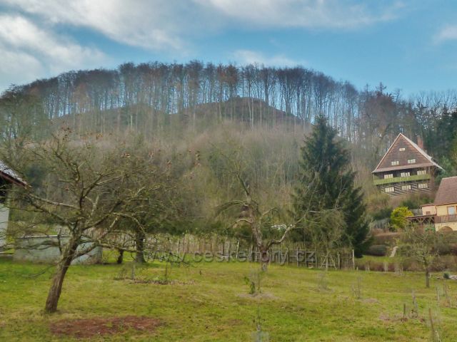 Zimní pohled k vrchu Žampach z jihu prozrazuje jeho dva vrcholy