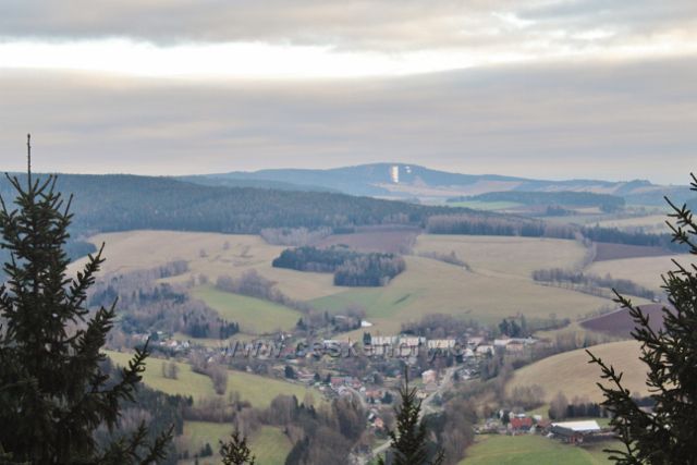 Pohled z rozhledového místa Studeneckých skal na Těchonín a v pozadí na zasněženou sjezdovku na Bukové hoře (958 m.n.m.)nad obcí Čenkovice