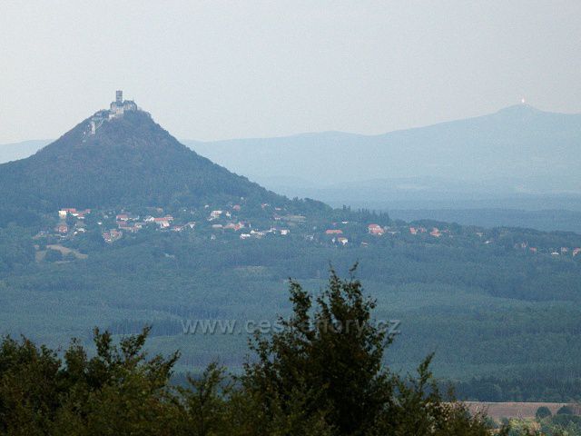 Hrad Bezděz z rozhledny na Vrátenské hoře, vpravo na obzoru odraz slunce od Ještědu.